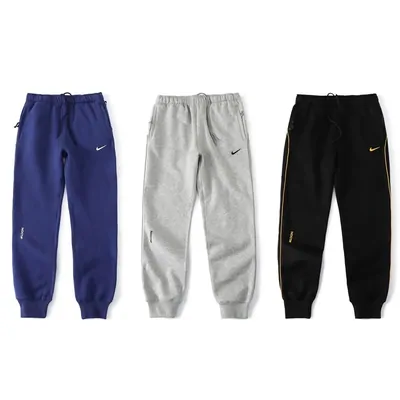 Tres pantalones de chándal en azul, gris y negro con cintura y puños visibles.